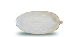 Handmade ceramic plate in the shape of a banana leaf, in a clear glaze, white colour, and an 18 karat gold rim around the edge. Great texture, feels good to the touch